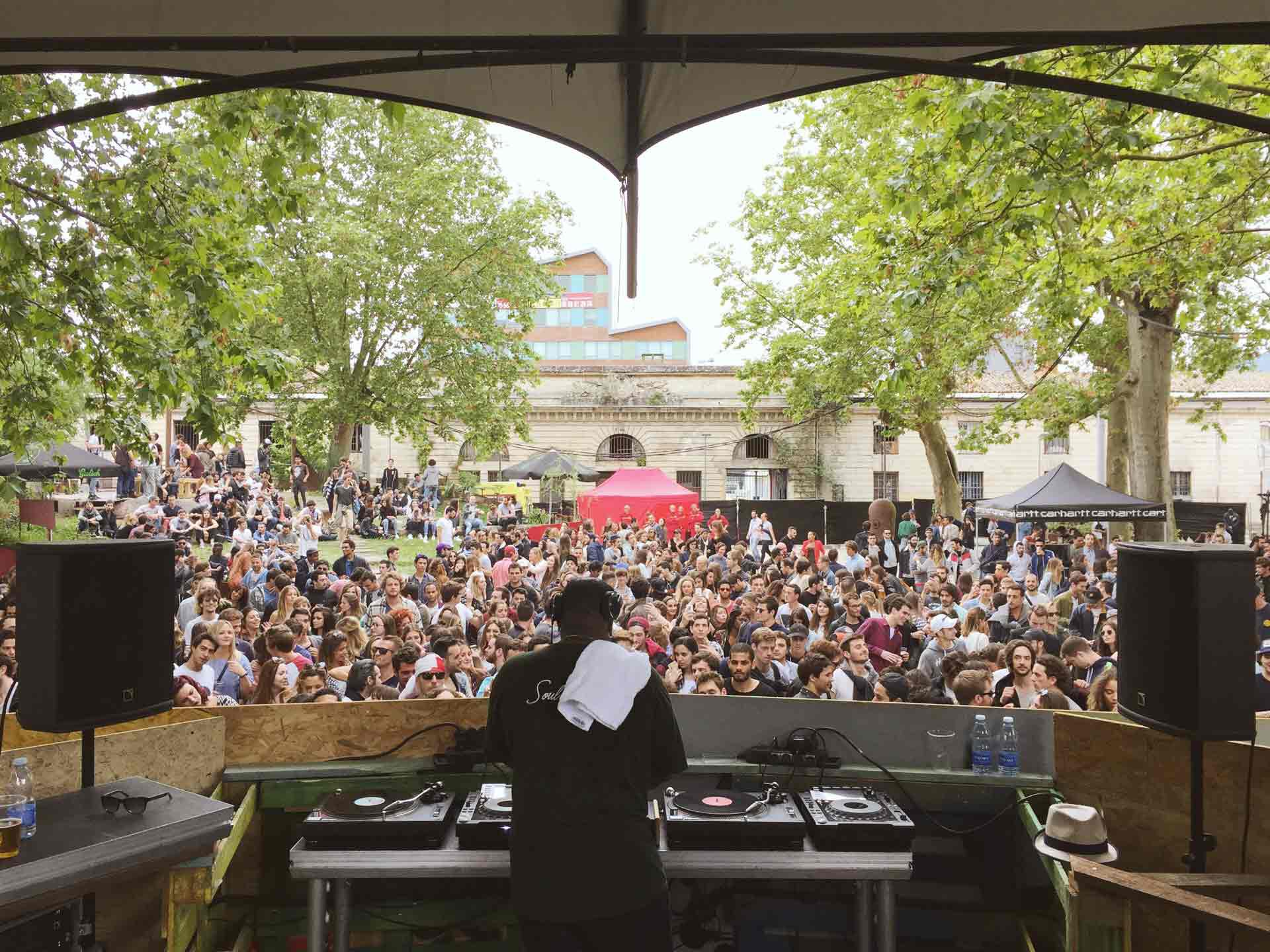 Un DJ qui mixe devant une foule de personnes.