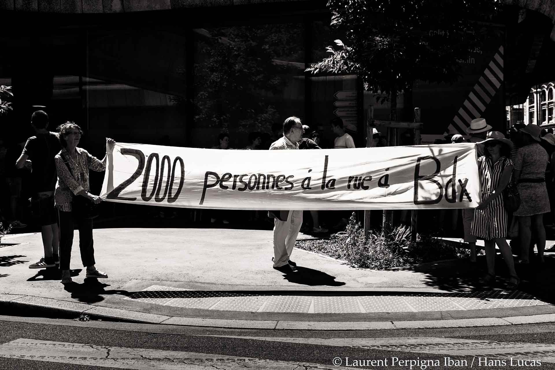 Une banderole tenue par deux femmes indique : "2 000 personnes à la rue à Bordeaux", en référence aux expulsions de squats.