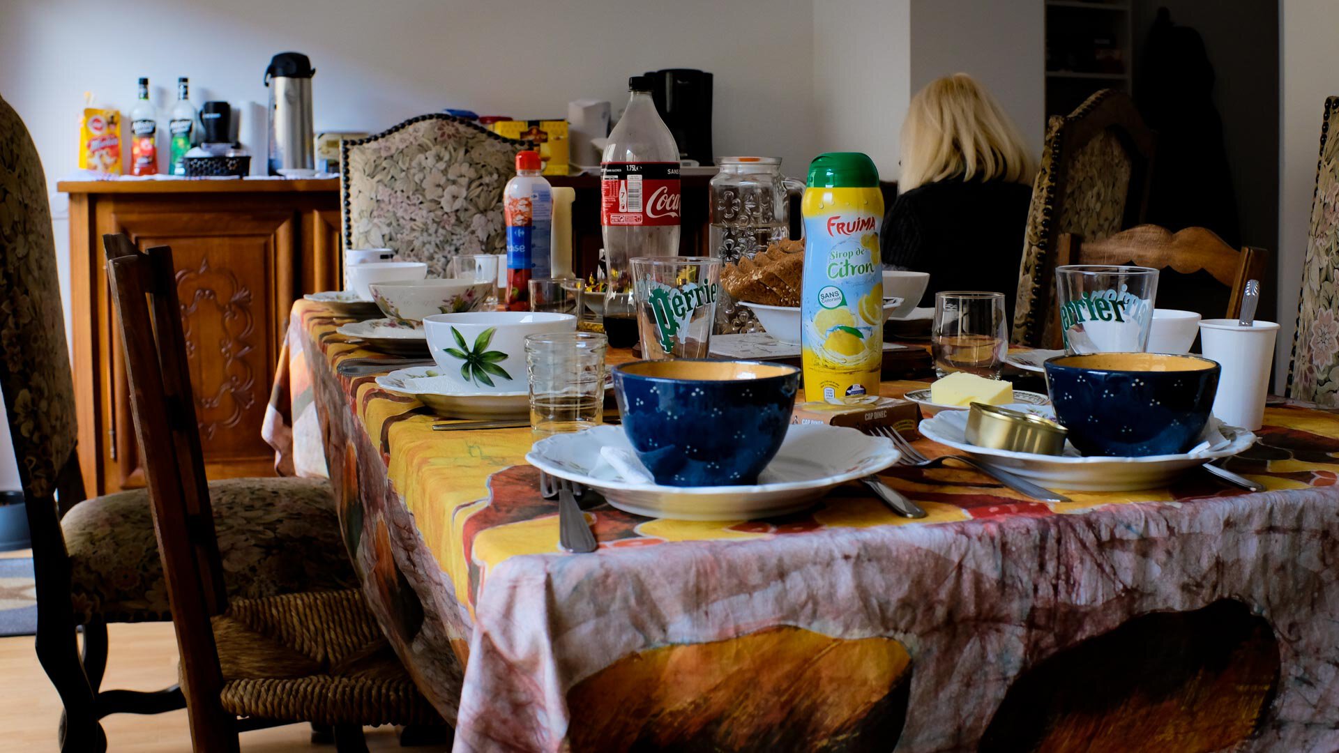 La table est mise dans la maison d'Élizabeth, avec des boisons et nourriture disposées sur la table. Le repas est dressé pour les personnes sans abri.