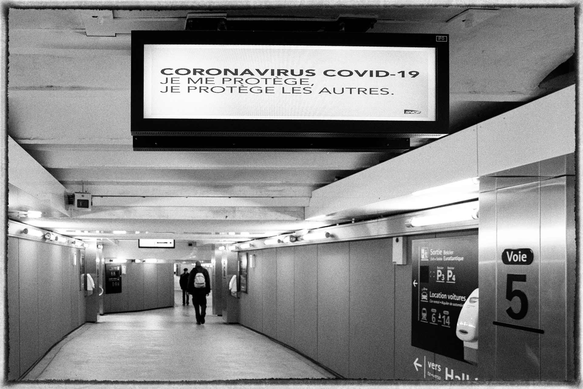 Dans la gare, un panneau diffuse "Coronavirus Covid-19, je me protège, je protège les autres."