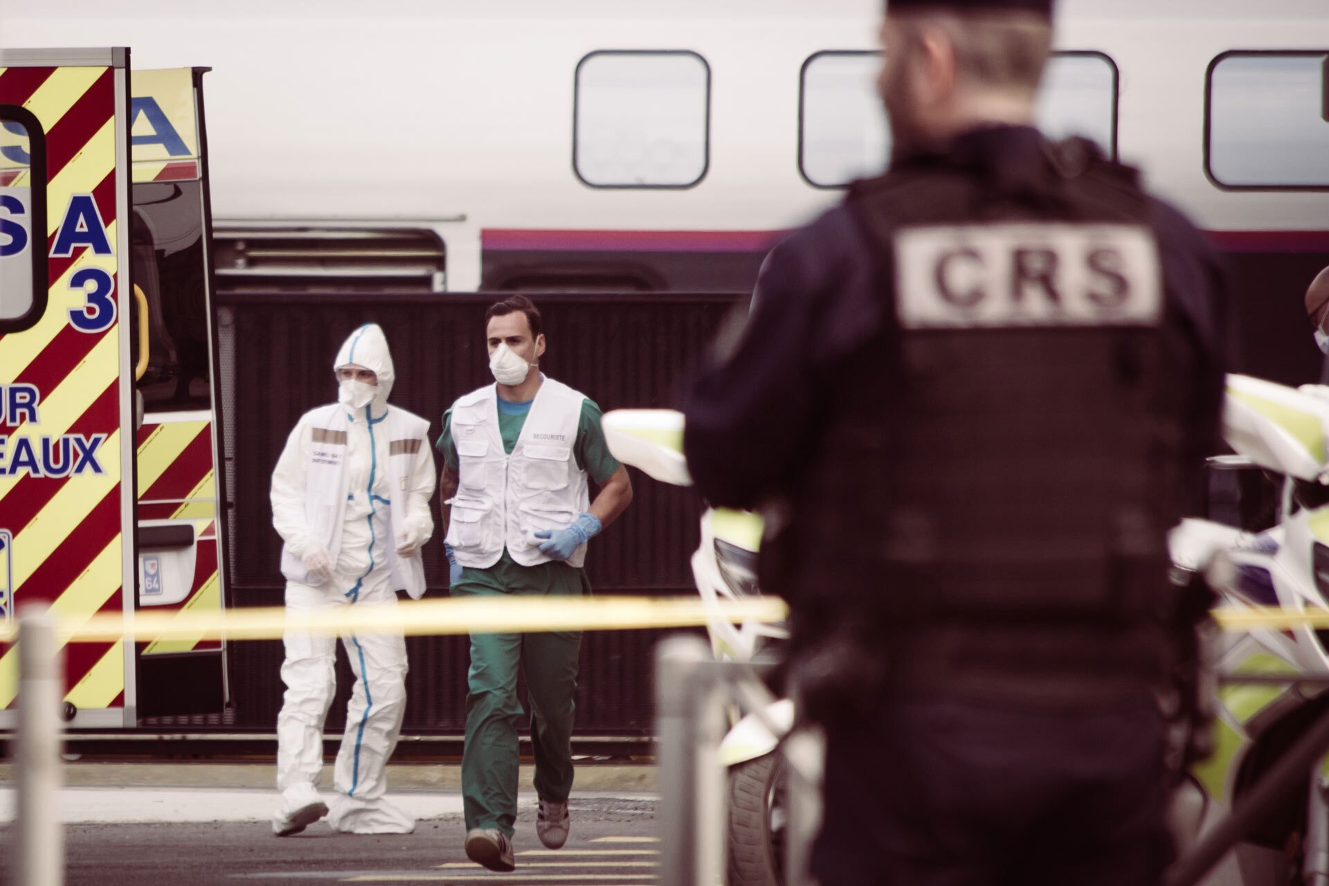 Des infirmiers et un CRS récupèrent un patient médicalisé dans un train, pour le mettre dans l'ambulance.