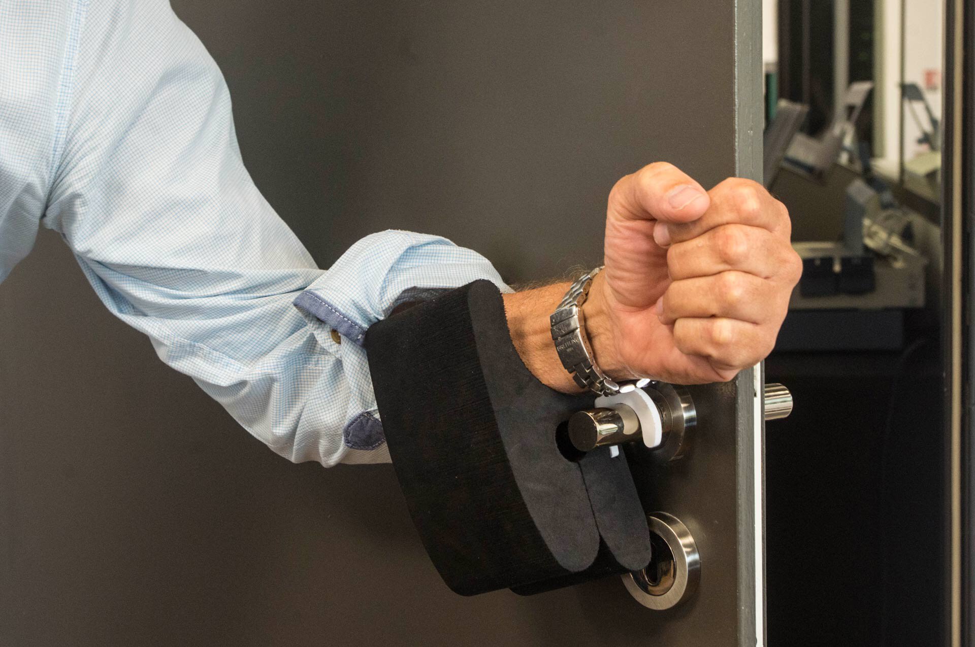 Stéphane Mangnez montre un exemple d'outil pour éviter de toucher les portes.