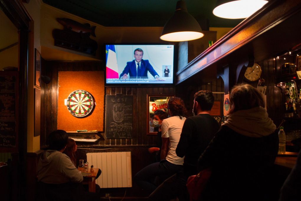 les clients d’un pub bordelais écoutent l’allocution d’Emmanuel Macron. 