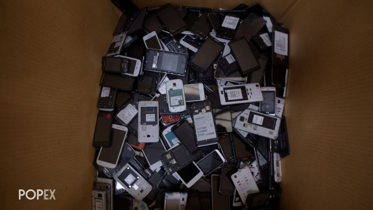 une caisse remplir de smartphone qui attendent le reconditionnement